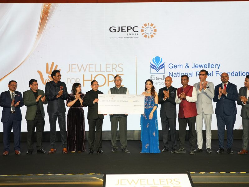 Kirit Bhansali Chairman GJEPC and Madhuri Dixit present the contribution to Shri Praveenshankar Pandya Chairman GJNRF in the presence of other dignitaries